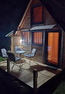 a deck with chairs and a table and a house at Star Cottage in Bajina Bašta