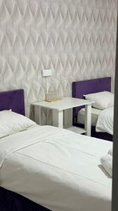 a bedroom with a bed and a table and chairs at MEIMAN hotel in Aktobe