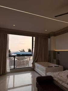 a bedroom with a bed and a large window at Kshitij 5 bros in Vasai