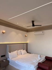 a bedroom with a large white bed with a ceiling at Kshitij 5 bros in Vasai +3 photos