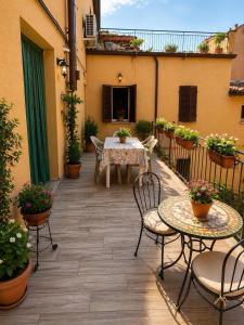 a patio with a table and chairs and plants at casadiviaappia in Imola