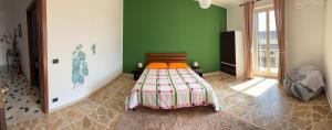 a bedroom with a bed in a room with green walls at La casa di Nerone in Acireale