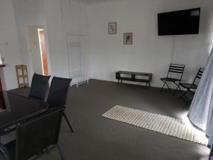 a living room with chairs and a flat screen tv at Koraalboom Guesthouse in Wolseley