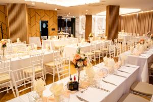 a banquet hall with white tables and white chairs at Aqua Hotel in Burgas +79 photos