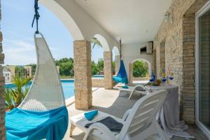 a patio with two hammocks and a swimming pool at Villa Amalfi in Medulin,Istrien in Medulin