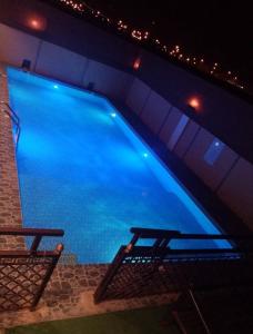 a swimming pool at night with two benches next to it at Hotel Reema Salalah in Salalah