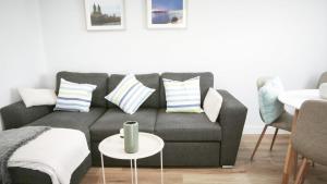 a living room with a gray couch with pillows at La Ilusión in Sanxenxo