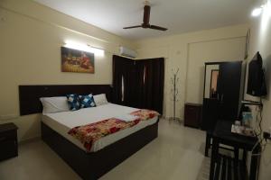 a bedroom with a bed and a television in it at Classique Inn Near Padmanabhaswamy Temple in Trivandrum