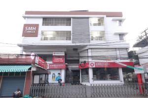a tall white building with a sign on it at Classique Inn Near Padmanabhaswamy Temple in Trivandrum
