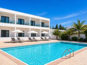 a hotel with a swimming pool in front of a building at Vergina Sun in Faliraki