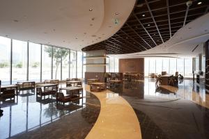 a large room with tables and chairs and windows at Tranquil Wellness Tower By Wellcube in Dubai