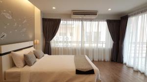 a bedroom with a bed and a large window at Ploen Place Residence in Pattaya Central +23 photos