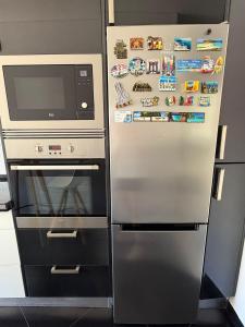 a refrigerator with a microwave next to a stove at Cozy Apartment Almada in Almada +11 photos