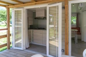 a kitchen with sliding glass doors on a patio at Camping 2 étoiles - Piscine - ccbgb0d in Sospel +30 photos