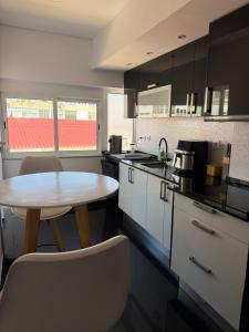 a kitchen with a table and a table and chairs at Cozy Apartment Almada in Almada