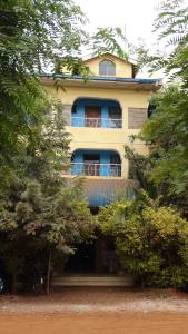 a yellow building with a balcony on the side of it at Sky Hotels Emali in Mwanda +1 photo