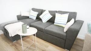 a living room with a gray couch and a table at La Ilusión in Sanxenxo