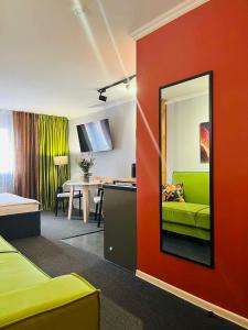 a living room with a green couch and a red wall at APART-HOTEl 95 in Almaty