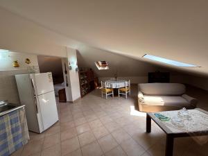 a kitchen and a living room with a refrigerator and a table at il SOLE DELL' ALCANTARA in Gaggi