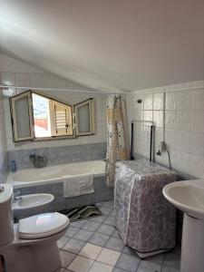a bathroom with a tub and a toilet and a sink at il SOLE DELL' ALCANTARA in Gaggi +7 photos