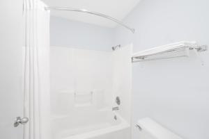 Un baño blanco con ducha y lavabo. en Super 8 by Wyndham Van Horn, en Van Horn 28 fotos más