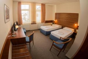 a hotel room with two beds and a desk at Hotel Karel IV. in Turnov +36 photos