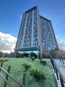 a tall building with a lawn in front of it at View Soft House - Quarto e Sala 213 in Lauro de Freitas