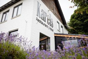 a building with purple flowers in front of it at Karels Restaurant Hotel in Braamt