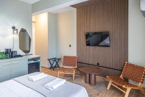 a hotel room with a bed and a tv on a wall at Ernest Suites Monastiraki in Athens