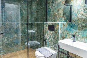 a bathroom with a shower and a toilet and a sink at Ernest Suites Monastiraki in Athens +110 photos