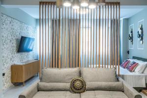 a living room with a couch and a bed at Ernest Suites Monastiraki in Athens