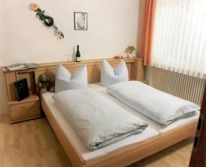 1 dormitorio con 2 camas y almohadas blancas en Sommerhof Rauber, en Immenstaad am Bodensee