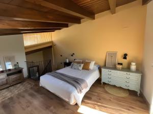 a bedroom with a white bed and a wooden floor at Casa Rural David in Chía