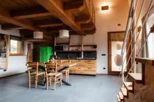 a kitchen with wooden ceilings and a table and chairs at Locanda Il Campo della Quercia in San Damiano Macra