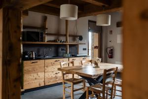 a kitchen with a wooden table and chairs at Locanda Il Campo della Quercia in San Damiano Macra +63 photos