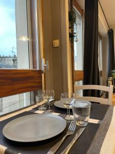 a table with a white plate and glasses on it at Le Cocon Cornouaillais, hyper centre, parking pv in Quimper