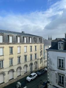 a view of a city with buildings and cars at Le Cocon Cornouaillais, hyper centre, parking pv in Quimper