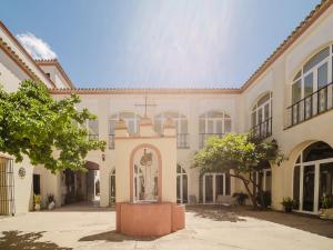 a large building with a statue in the courtyard at Casa Rural El Charruado in Sanlúcar de Barrameda