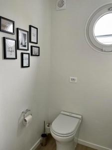 a bathroom with a toilet with pictures on the wall at AURORA in Lübeck +13 photos