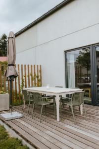 a table and chairs on a deck with an umbrella at Druhej Domek u ráje in Bystřice