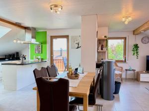 a kitchen and dining room with a table and chairs at Ferienwohnung Wohlfühloase - gemütliche Familienunterkunft in ruhiger Lage in Achberg