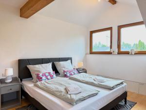 two beds in a room with two windows at Ferienwohnung Wohlfühloase - gemütliche Familienunterkunft in ruhiger Lage in Achberg