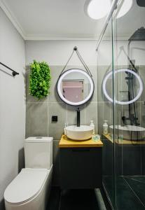 a bathroom with a toilet and a sink and a mirror at APART-HOTEl 95 in Almaty +20 photos