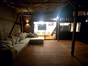 a living room with a couch in a room with lights at Luxe Tiny Home in Whangarei