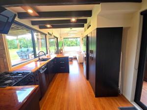 an rv kitchen with a sink and a stove at Luxe Tiny Home in Whangarei