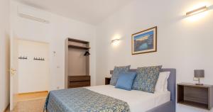 a bedroom with a bed with blue pillows at Residenza Simeon Grande - Luxurious modern apartment in Venice