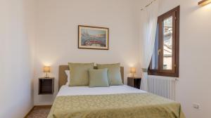a white bedroom with a bed and a window at Residenza Simeon Grande - Luxurious modern apartment in Venice