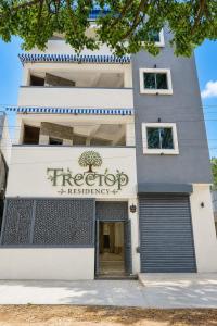 a building with a sign on the front of it at Tree Top Residency in Mysore