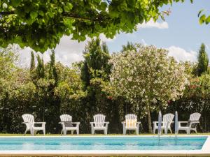 a group of chairs sitting next to a swimming pool at Casa Rural El Charruado in Sanlúcar de Barrameda