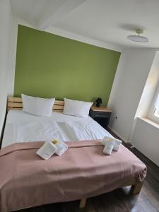 a bedroom with a bed with a green wall at Naturparadies an der Saale in Könnern +25 photos